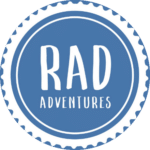 BLUE circular badge with white scalloped border, featuring the words 'RAD ADVENTURES' in white text.